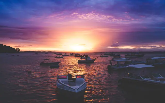 Pôr do sol em Morro de São Paulo, com barcos parados na água